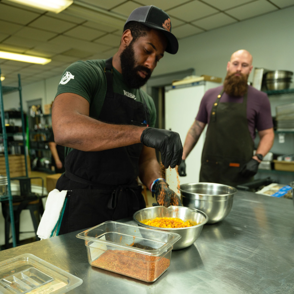 Two men preparing food in a kitchen setting